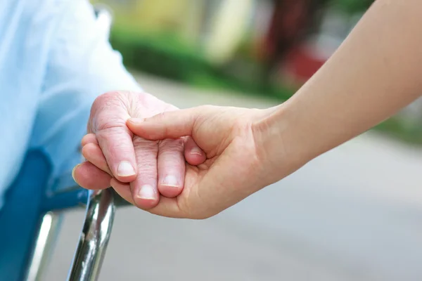 Äldre kvinnor i rullstol som håller hand — Stockfoto