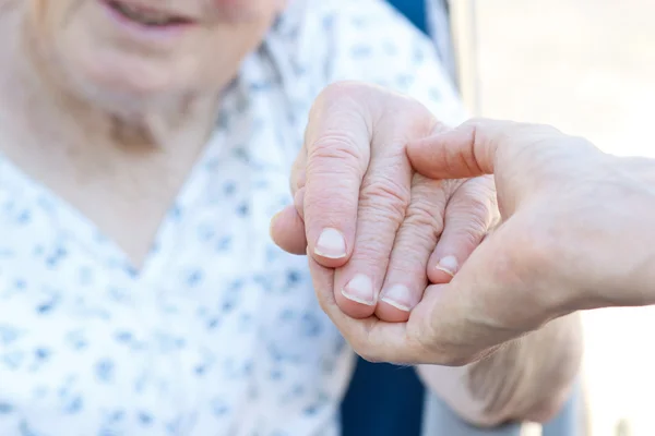Femme âgée tenant la main avec le gardien — Photo