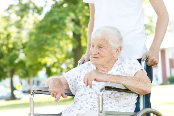 Mulheres seniores em cadeira de rodas com cuidador — Fotografia de Stock