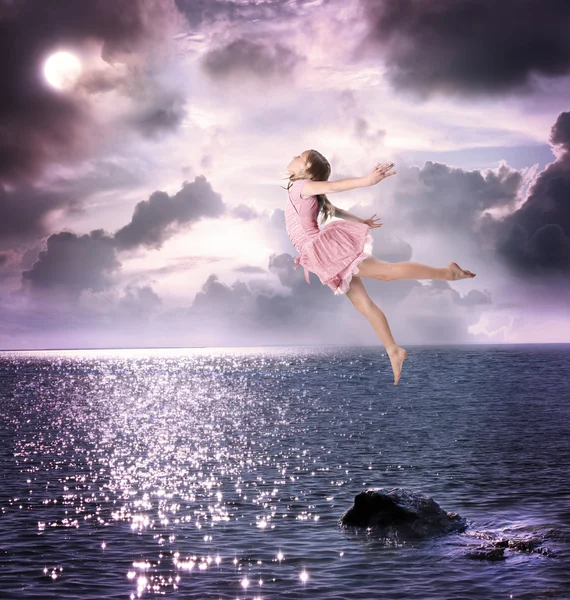 Klein meisje springen in de nachtelijke hemel — Stockfoto