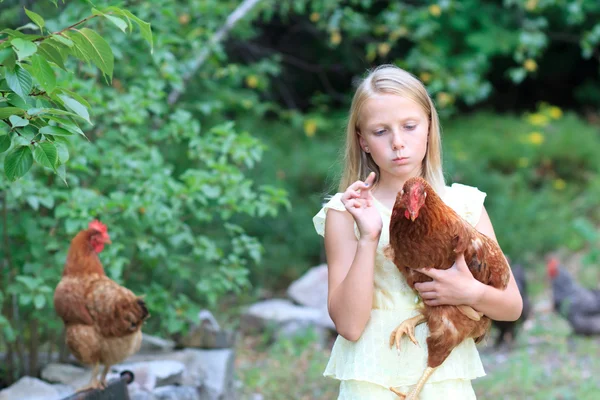 Blondes Mädchen im Garten mit Hühnern — Stockfoto