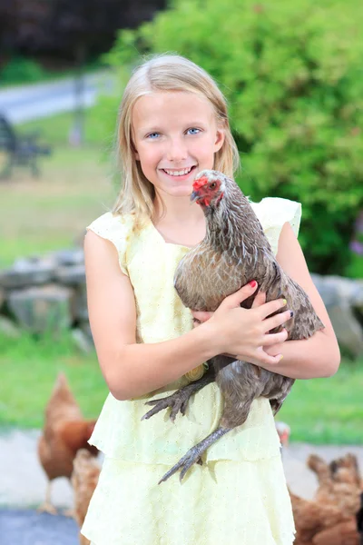 Blond tjej i trädgården med kycklingar — Stockfoto