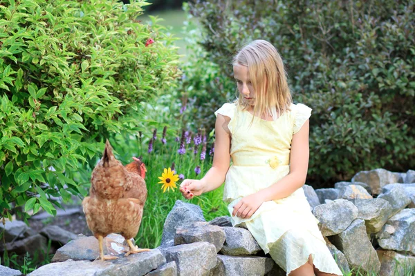 Blondes Mädchen im Garten mit Hühnern — Stockfoto