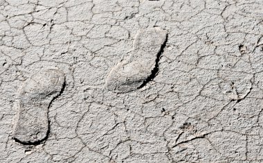 Footprints on a dry cracked land clipart