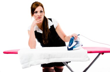 Beautiful brunette woman irons clothes on the ironing board clipart