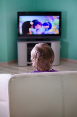 Little boy watching cartoon in television clipart