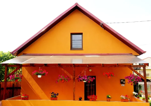 Апельсиновый дом с цветами — стоковое фото