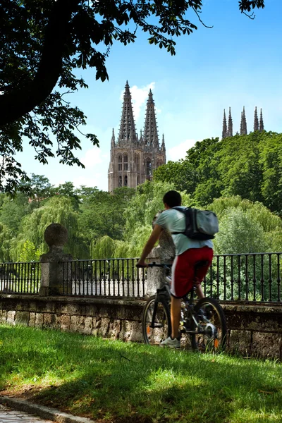 Városi kerékpáros, Burgos gótikus katedrális, a háttérben. Spanyolország — Stock Fotó