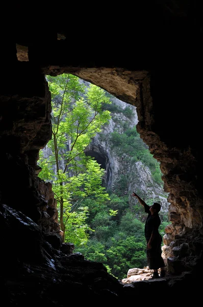 男子站在一个山洞入口处 — 图库照片