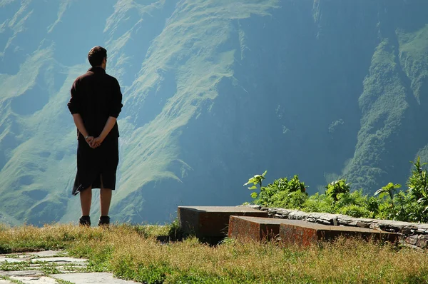 Homem no topo da montanha olhando para o horizonte — Fotografia de Stock