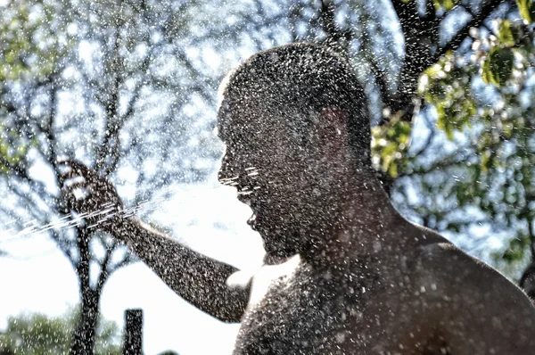 Maschio gode la spruzzata d'acqua in mezzo alla natura — Foto Stock
