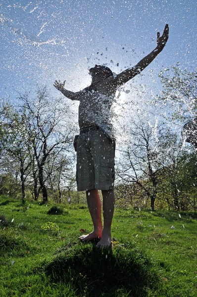 Male enjoys the water splash in the outdoors — Stock Photo, Image