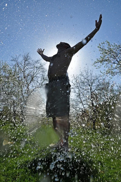 Férfi élvezi a víz csobbanás a szabadban — Stock Fotó