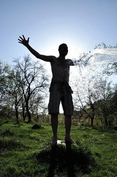 Macho disfruta de la salpicadura de agua en el aire libre — Foto de Stock
