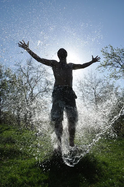 Male enjoys the water splash in the outdoors — Stock Photo, Image
