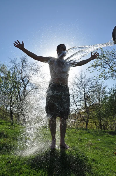 男性は屋外の水のしぶきを楽しんでいます — ストック写真