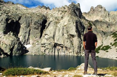 Man standing in the front of a mountain lake clipart
