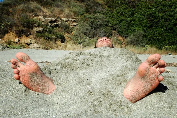 Uomo ricoperto di sabbia sulla spiaggia — Foto Stock