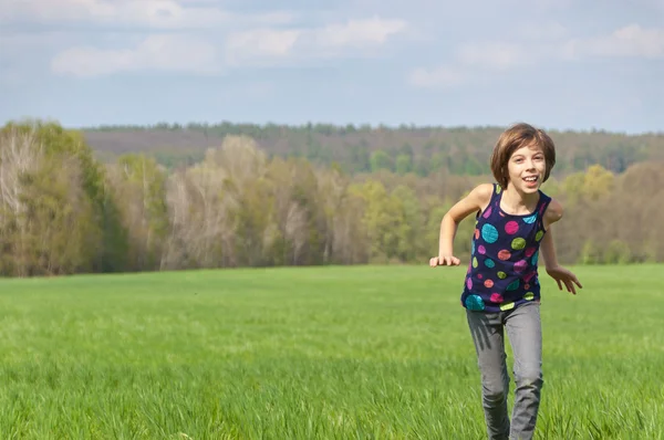 快乐活泼的女孩，在绿色的原野上运行 — 图库照片