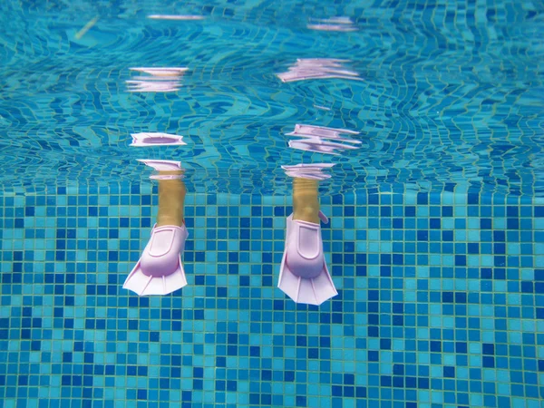 Pernas de criança subaquática em barbatanas na piscina — Fotografia de Stock