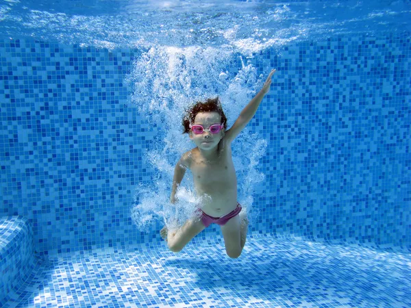 Счастливый подводный ребенок прыгает в бассейне — стоковое фото