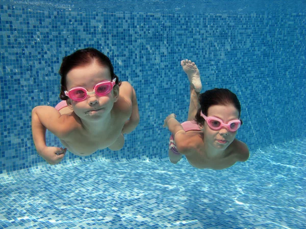 Счастливые улыбающиеся подводные дети в бассейне — стоковое фото
