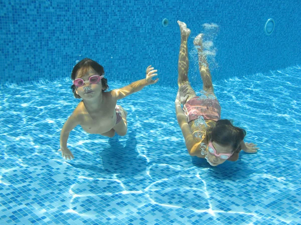 Счастливые улыбающиеся подводные дети в бассейне — стоковое фото