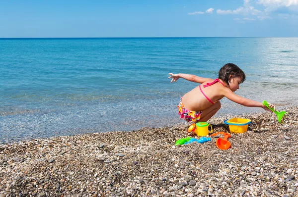 Little girl playing with toys on the beach — Stock Photo, Image