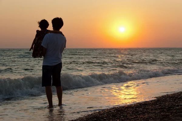 Padre e bambino sulla spiaggia del tramonto — Foto Stock