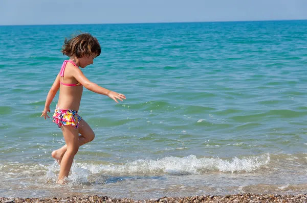Kind en zee. lopende jongen op het strand — Stockfoto