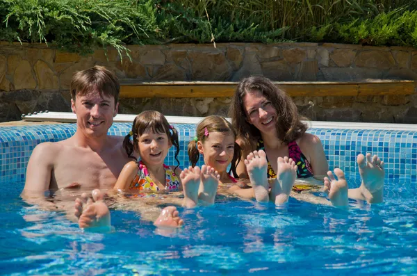 Щаслива сім'я з двома дітьми в басейні — стокове фото