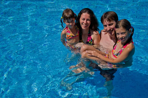 Famille heureuse avec deux enfants dans la piscine — Photo