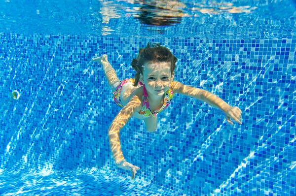 Feliz niño sonriente bajo el agua en la piscina — Foto de Stock