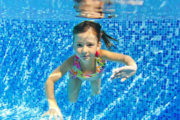 Счастливый улыбающийся подводный ребенок в бассейне — стоковое фото