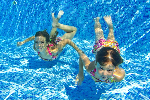 Glücklich lächelnde Unterwasserkinder im Schwimmbad — Stockfoto