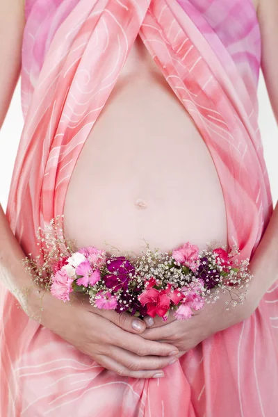 Κοιλιά της εγκύου γυναίκας με λουλούδια — Φωτογραφία Αρχείου