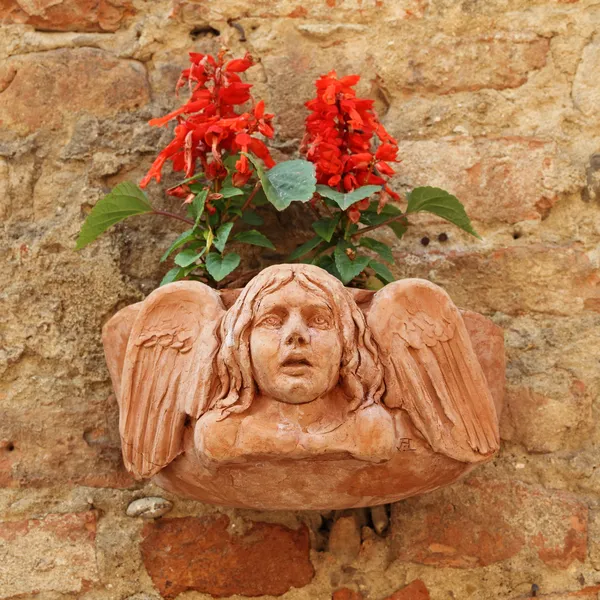 Terracotta flowerpot with angelic relief — Stock Photo, Image