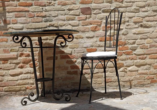 Железное кресло и стол на солнечной террасе — стоковое фото