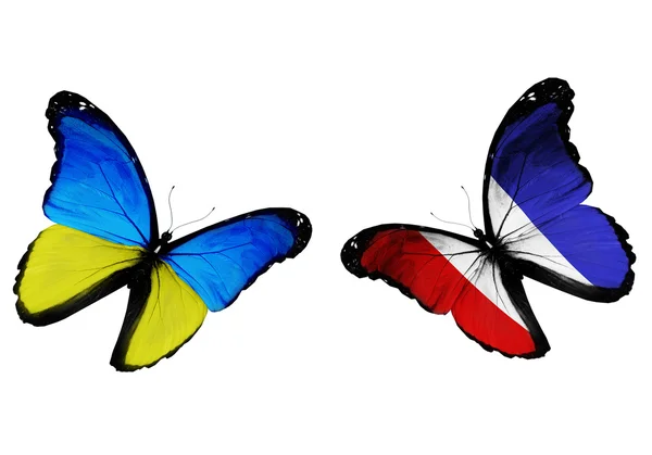 Conceito - duas borboletas com bandeiras ucranianas e francesas voando — Fotografia de Stock