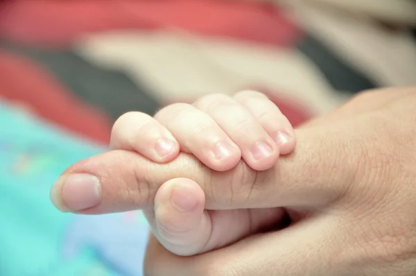 Dedo da mãe na mão da criança — Fotografia de Stock