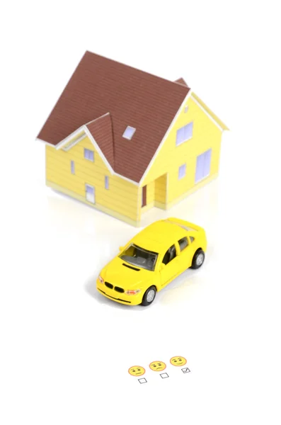 Іграшковий автомобіль, модель будинку та обличчя — стокове фото