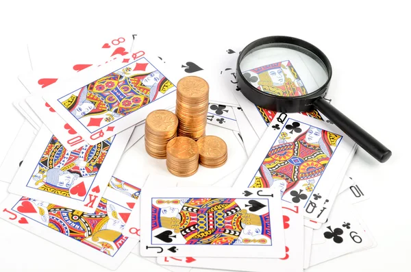 Покер и монеты с лупой — стоковое фото