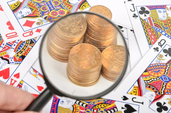 Poker and coins with magnifier — Stock Photo, Image