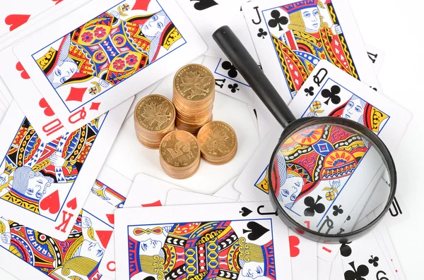 Poker y monedas con lupa —  Fotos de Stock