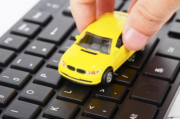 Počítačové klávesnice a hračka auto — Stock fotografie
