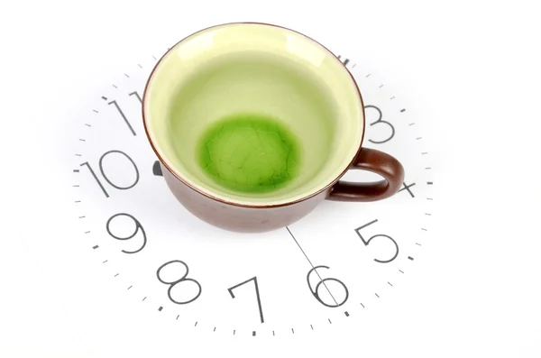 Xícara de chá na cara do relógio — Fotografia de Stock