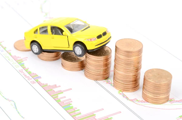 Spielzeugauto und Münzen auf Finanzdiagramm — Stockfoto
