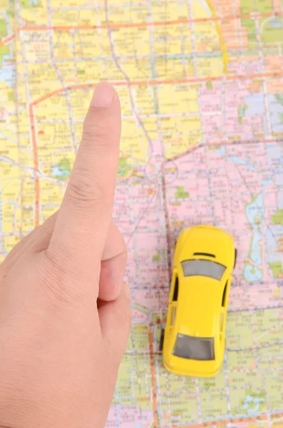 Игрушечный автомобиль и карта с пальцем — стоковое фото