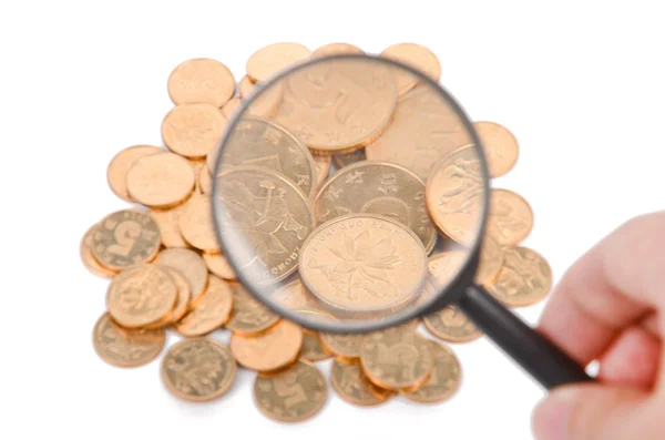 Magificador e moedas sobre fundo branco — Fotografia de Stock