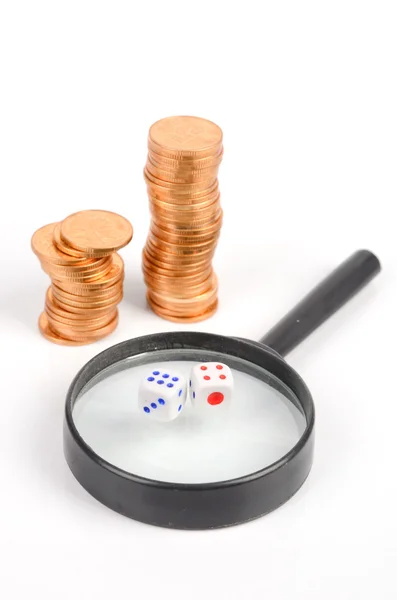 Coins and magnifier with dices — Stock Photo, Image
